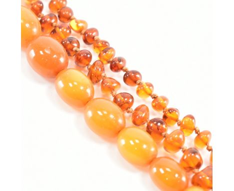 Two vintage amber beaded necklaces. The first comprised of organically shaped graduating clear amber beads spaced by knotted 
