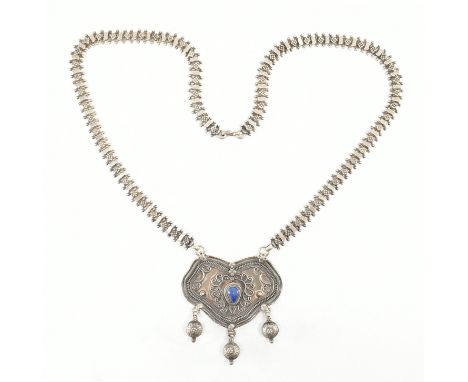 A vintage silver &amp; lapis lazuli pendant necklace. The necklace having a central pearl cut bezel set lapis cabochon surrou