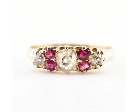 A hallmarked Victorian red stone and diamond ring. The ring set with a central old cut diamond having four red stone accents 