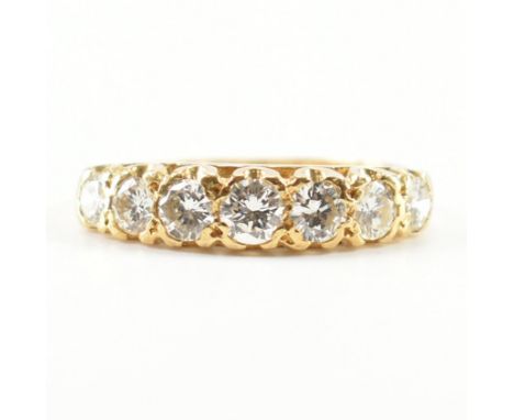 A hallmarked 18ct yellow gold &amp; diamond seven stone ring. The ring having having a central round cut diamond with three f