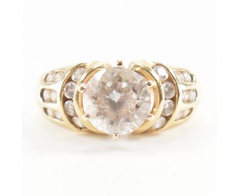 A hallmarked 14ct yellow gold &amp; cubic zirconia ring. The ring having a central round cut prong set white stone suspended 