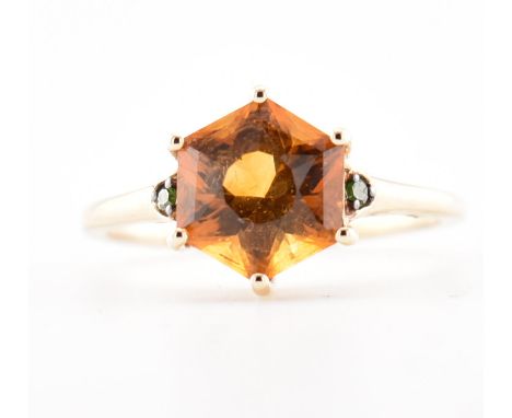 A hallmarked citrine and greenstone ring. The ring set with a central round mixed cut citrine of rich colour flanked by two g