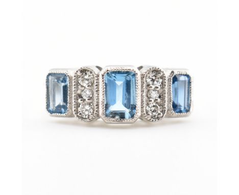 A hallmarked aquamarine and diamond 950 platinum three stone ring. The ring set with three step cut aquamarines having&nbsp; 