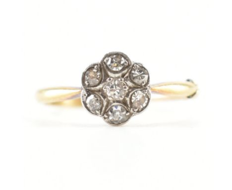 An early 20th Century antique 18ct gold and diamond flower head ring. The ring being set with seven round cut diamonds on pla