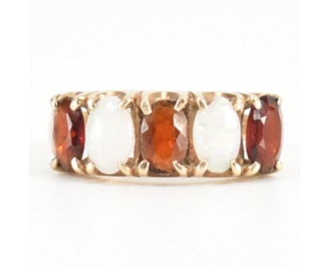 A hallmarked 9ct yellow gold, garnet &amp; opal five stone ring. The ring having three oval cut garnets spaced by two oval op