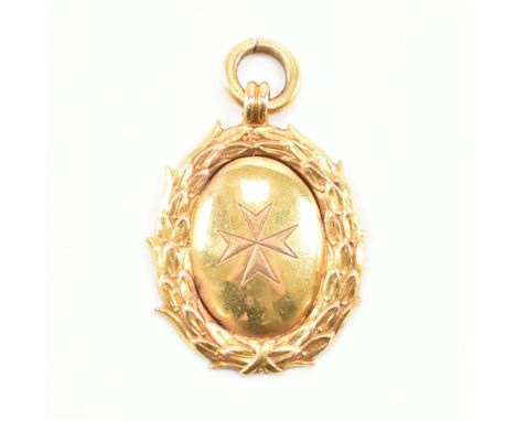 A hallmarked 9ct yellow gold fob medal pendant. The pendant of oval form, having a Maltese cross etched to the centre surroun