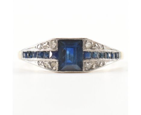 An Art Deco sapphire and diamond plaque ring. The ring set with a central emerald cut sapphire with calibre cut sapphire and 