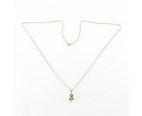 A vintage gold emerald and diamond flower pendant necklace. The necklace having a fine link chain with a gold pendant in the 