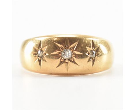 A hallmarked 18ct gold and diamond dome ring. The ring being set with three round cut diamonds in star settings. Hallmarked C