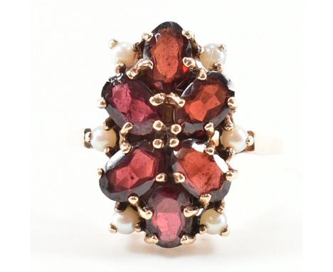 A hallmarked 9ct gold, garnet and pearl cluster ring. The ring being set with six oval cut garnets and six seed pearls. Hallm