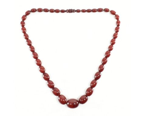 A vintage cherry bakelite beaded necklace. The necklace comprised of graduated olive shaped deep red early plastic bakelite b