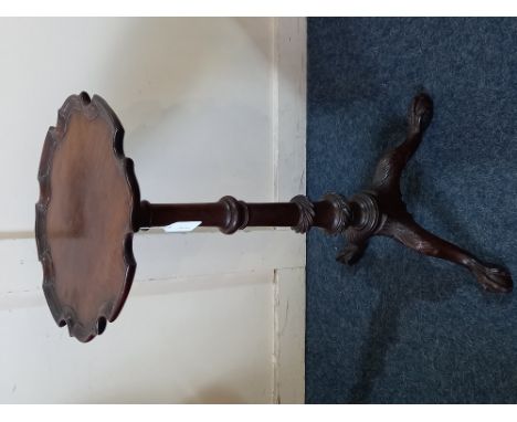 A George III Chippendale style carved mahogany wine table with circular pie crust top, wrythen baluster stem and three acanth