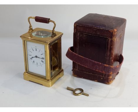 A French brass carriage clock, the back plate stamped 'Paris', white enamel dial with Roman numerals, 17cm high, with fitted 