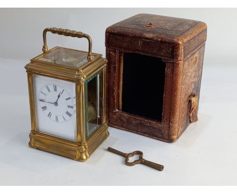 A French brass repeater carriage clock, the back plate stamped 'Paris', white enamel dial with Roman numerals, 18cm high, wit