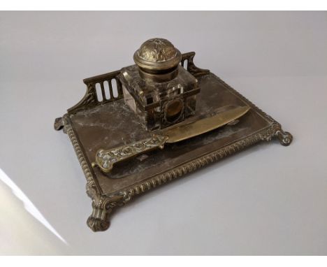 A brass desk stand with glass inkwell, 23cm, and a brass paper knife