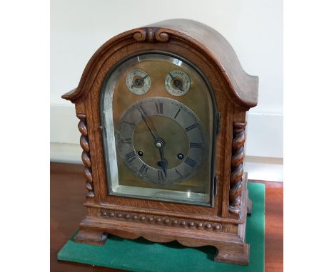 An early 20th century oak mantle clock with brass dial and silvered chapter ring, gong striking movement in domed case, on br