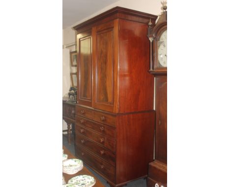 A mahogany secretaire linen press cupboard in the manner of Gillows top with flame veneer doors enclosing four sliding shelve