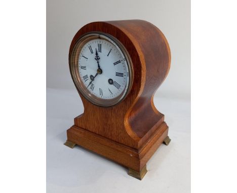 An oak balloon cased mantle clock, the circular white dial with Roman numerals, striking on a bell, 24cm high, with pendulum 