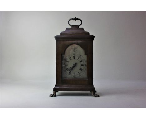 An 18th century style walnut mantle clock with arched steel dial, cushion top and handle on four brass paw feer, 29cm