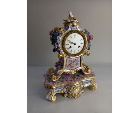 A 19th Century French porcelain mantle clock, the white enamel dial with Roman numerals, movement striking on a bell, inscrib