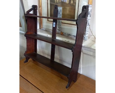 An oak three tier wall shelf with fret cut supports 59cm 