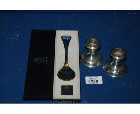 A Silver gilded and enamel Spoon by Georg Jensen and a pair of small Silver Candlesticks,