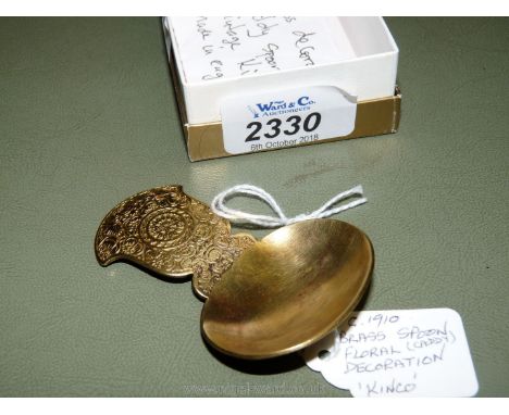 An English 1910 brass Caddy Spoon (Kinco) with floral decoration.