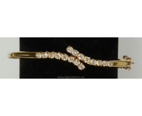 A gold Bangle (no mark visible) set with 16 diamonds.