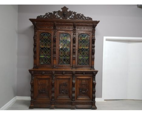 A 19TH/EARLY 20TH CENTURY CONTINENTAL HEAVILY CARVED OAK SIDEBOARD WITH STAINED GLASS PANEL DOORS 183.5 X 276 X 64CM APPROX