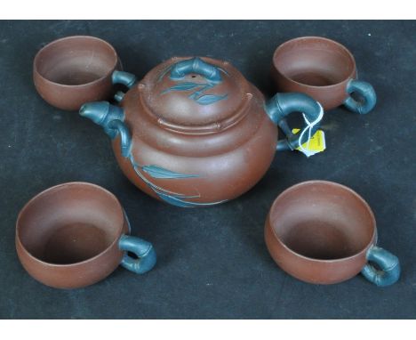 A vintage 20th century Chinese Yixing terracotta / stoneware tea service comprising of teapot alongside a set of four teacups