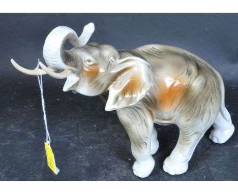 A vintage 20th century porcelain china Royal Dux Czechoslovakian ornament of an Elephant raising its trunk. Measures 22cm hig