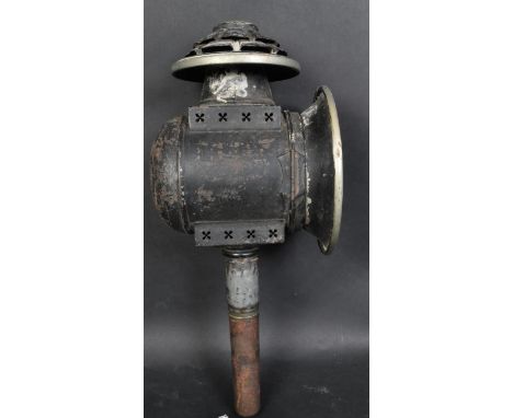An early 20th century Coaching lamp having a vented lid, circular shade raised on an upright support. The lamp is constructed