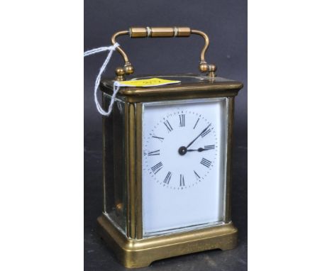 An early 20th century brass cased carriage clock. The clock having a white face with roman numeral to the chapter ring, swan 
