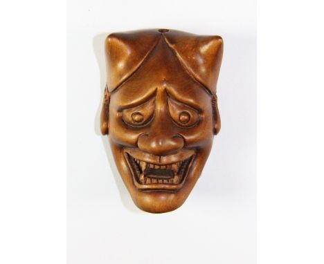 An unusual Devil mask carved fruitwood netsuke