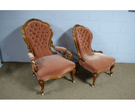 A Victorian carved walnut 'show frame' gentleman’s easy chair and matching lady’s chair, each with button upholstered backs a