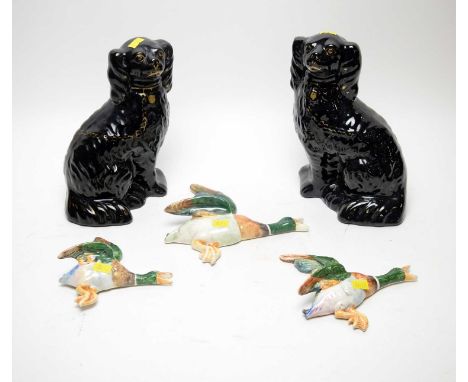 A graduated set of three ceramic bird wall plaques, in the manner of Beswick, unmarked; together with a pair of black Jetware