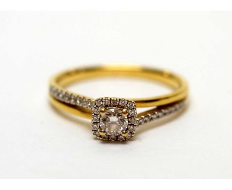 A diamond cluster ring, the central brilliant cut diamond weighing approximately 0.20carats, surrounded by a diamond bezel an