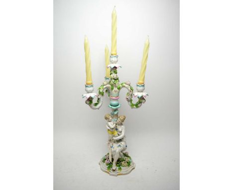 A Dresden figural three-branch candelabra, modelled as a mother and child, with floral encrusted branches and base, indistinc