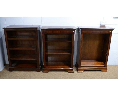 A pair of reproduction mahogany open bookcases, the rectangular banded top above adjustable shelves, fluted sides, on shaped 