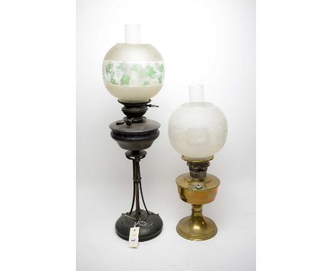 An Art Nouveau lacquered metal oil lamp, 74cms high including shade and funnel; together with a brass oil lamp. (2)