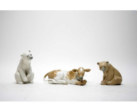 A Lladro ceramic polar bear figure, 12cms high; together with anther Lladro bear; and a Lladro cow. (3)