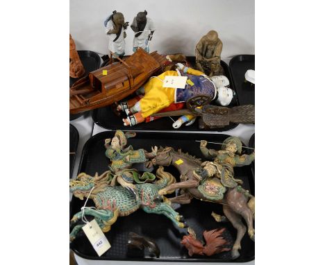 A selection of Oriental decorative ceramic figures; together with other collectible wares, including a treen model boat, on s