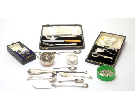 A selection of silver items, including: a cream jug; a sauce ladle; napkin ring; butter knives; teaspoons and other items. 