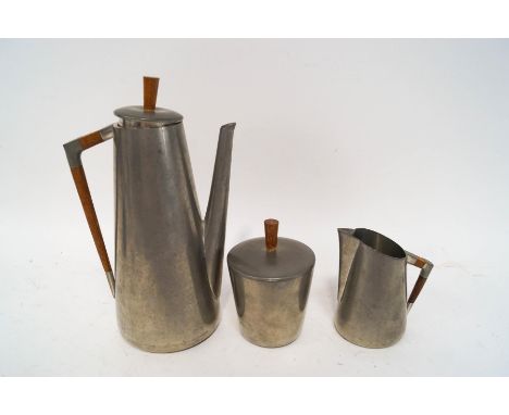 A Royal Holland pewter three piece tea service, with turned wooden finials 