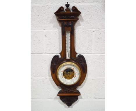 A Victorian mahogany aneroid barometer with carved applied mounts and visible workings, 100cm high