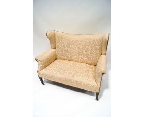 An Edwardian two seat wing back sofa, with foliate patterned upholstery, 131cm wide