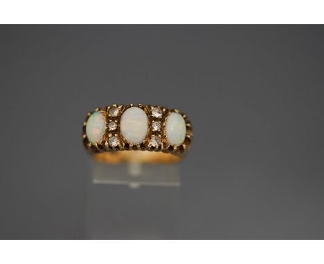 A 9ct gold three stone opal ring, with trios of colourless stones in between, 7.7 g gross