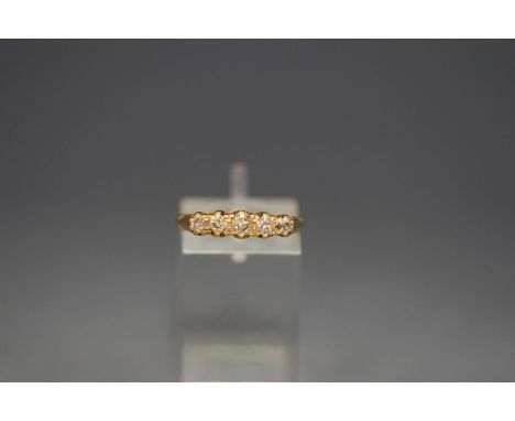 An 18 carat gold five stone diamond ring, the graduated old cuts to a carved head mount, finger size M, 3.2 g gross