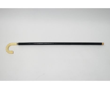 An ebonised walking stick with faux ivory handle