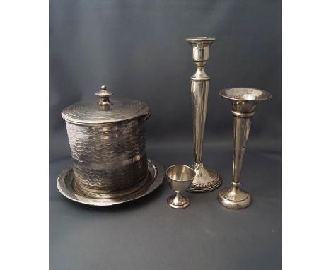 A loaded candlestick, stamped 'Sterling'; a silver loaded bud vase; a silver egg cup; and a plated biscuit barrel